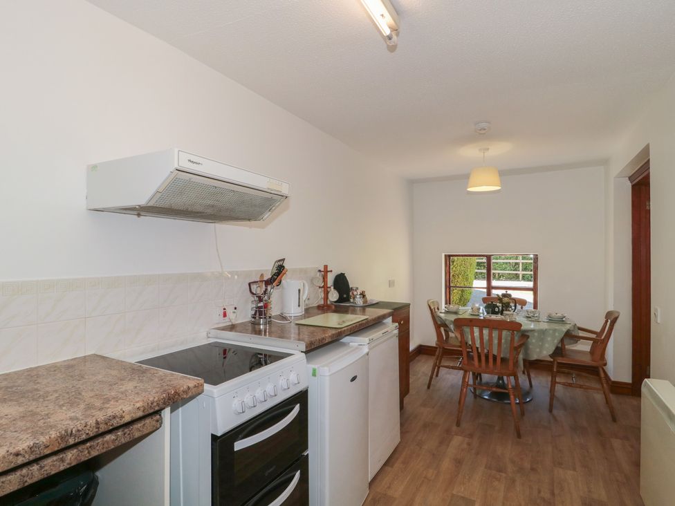 A kitchen with oven and dining table at Walk Close in Gloucester