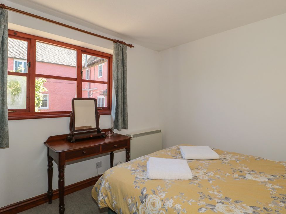 A bedroom with a bed, desk, and window at Walk Close in Gloucester
