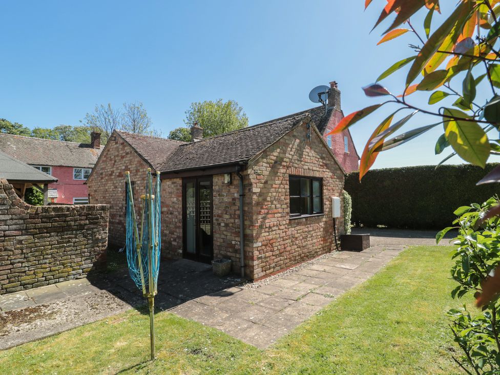 A garden with a brick house and a satellite dish at Walk Close in Gloucester