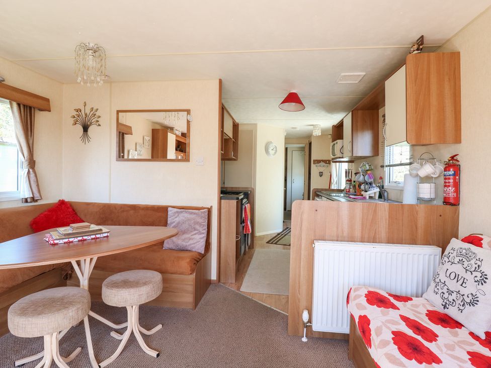 A dining room with a table and kitchen area at Valley Farm Number 448