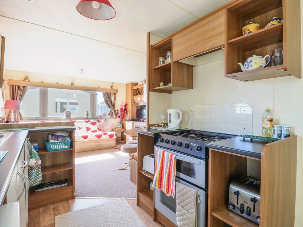 A kitchen with appliances and a living area at Valley Farm Number 448