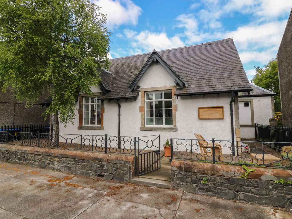 A house with a fenced area and trees at The Old School in Peebles