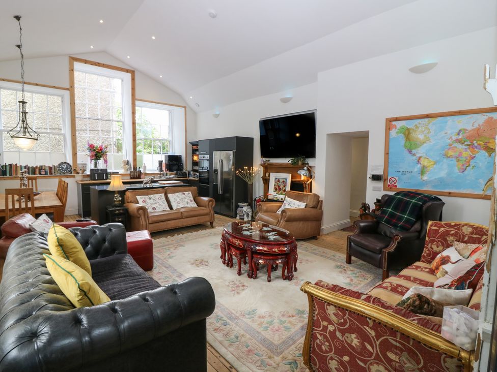 A living room with a sofa and dining area at The Old School in Peebles
