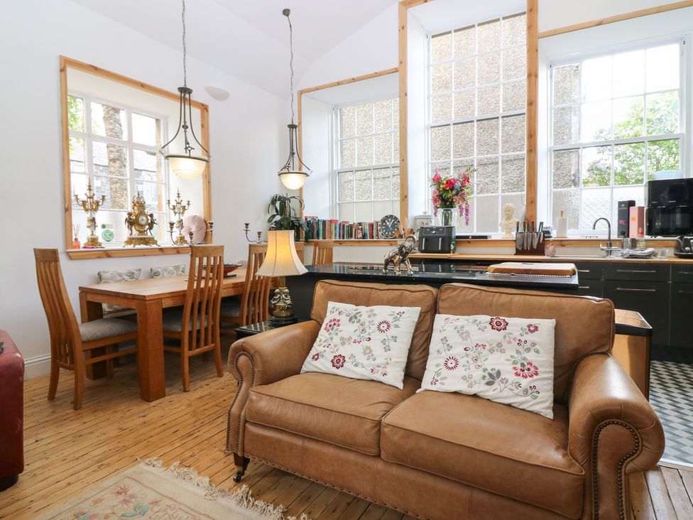 A living room with a sofa and dining table at The Old School in Peebles