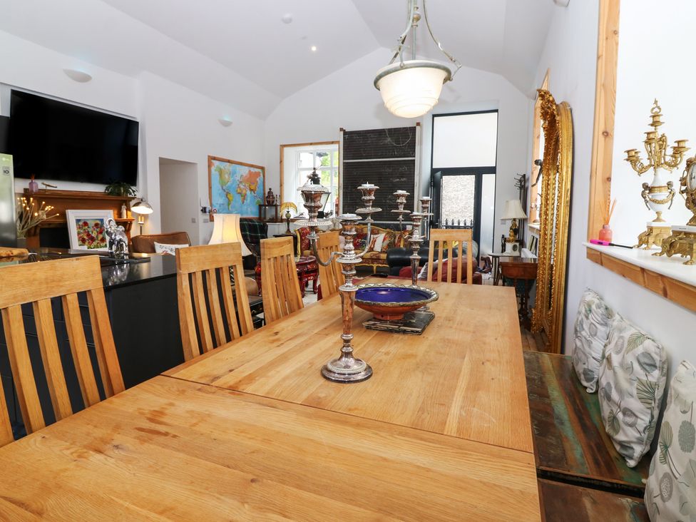 A dining room with a large table and seating at The Old School in Peebles