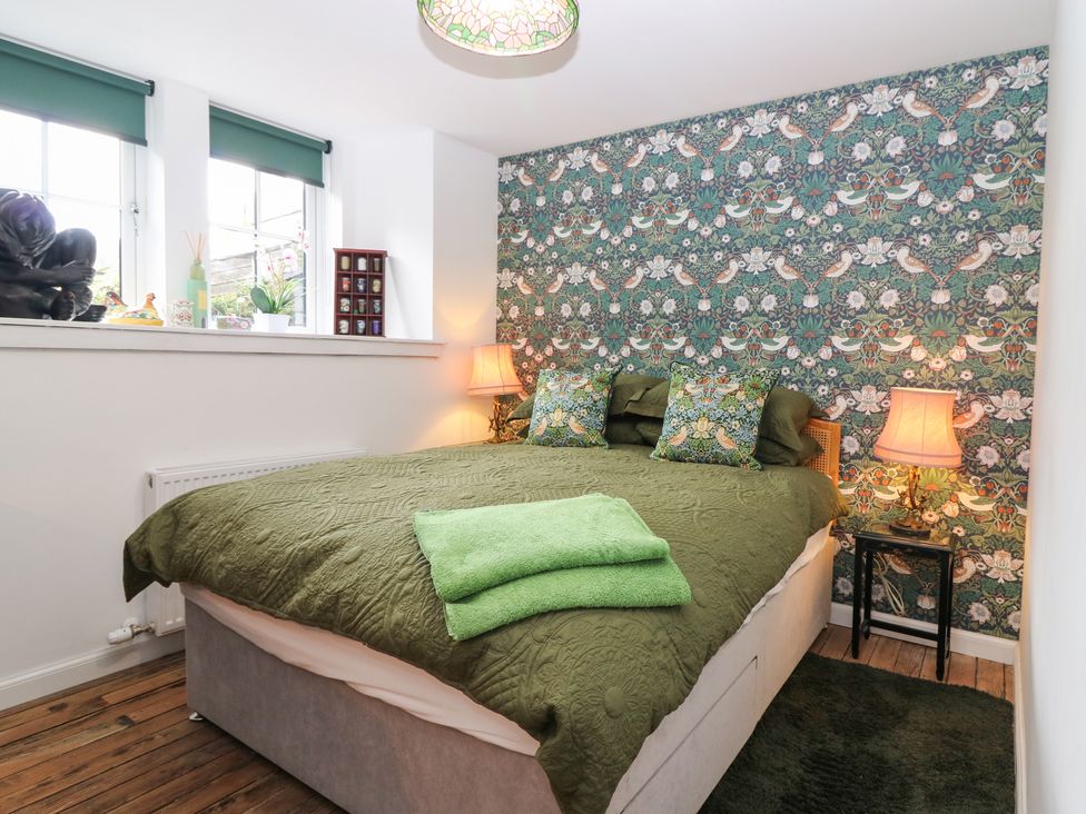A bedroom with a bed and decorative pillows at The Old School in Peebles