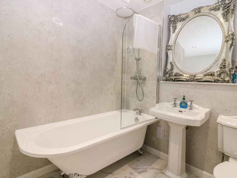 A bathroom with a bathtub, shower, washbasin, and toilet at The Old School in Peebles