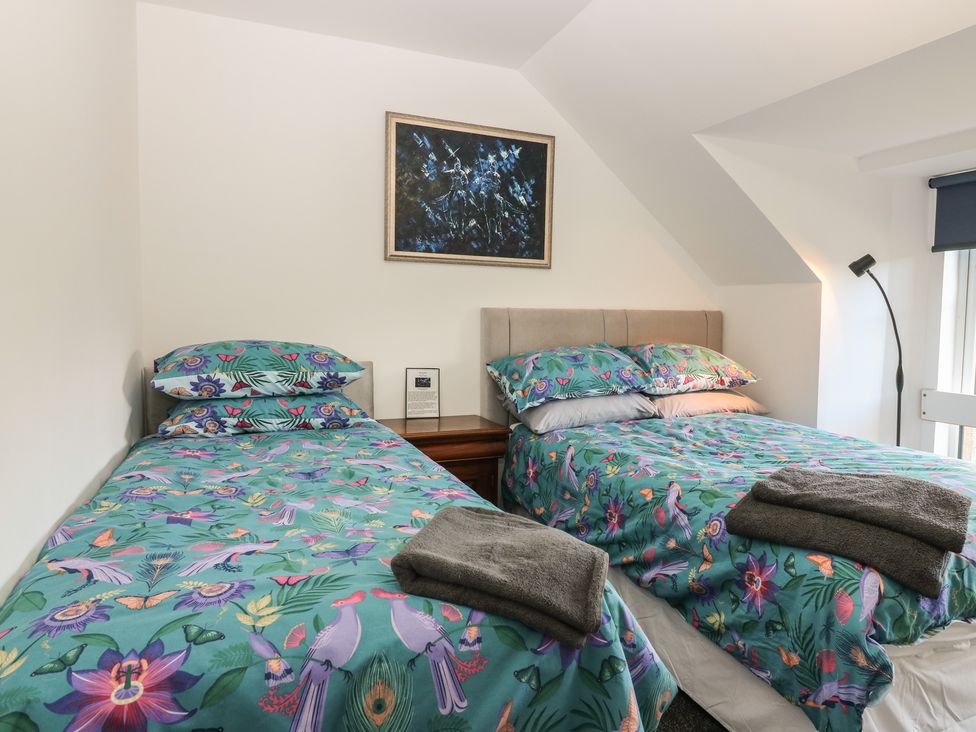 A bedroom with two beds and a painting on the wall at The Old School in Peebles