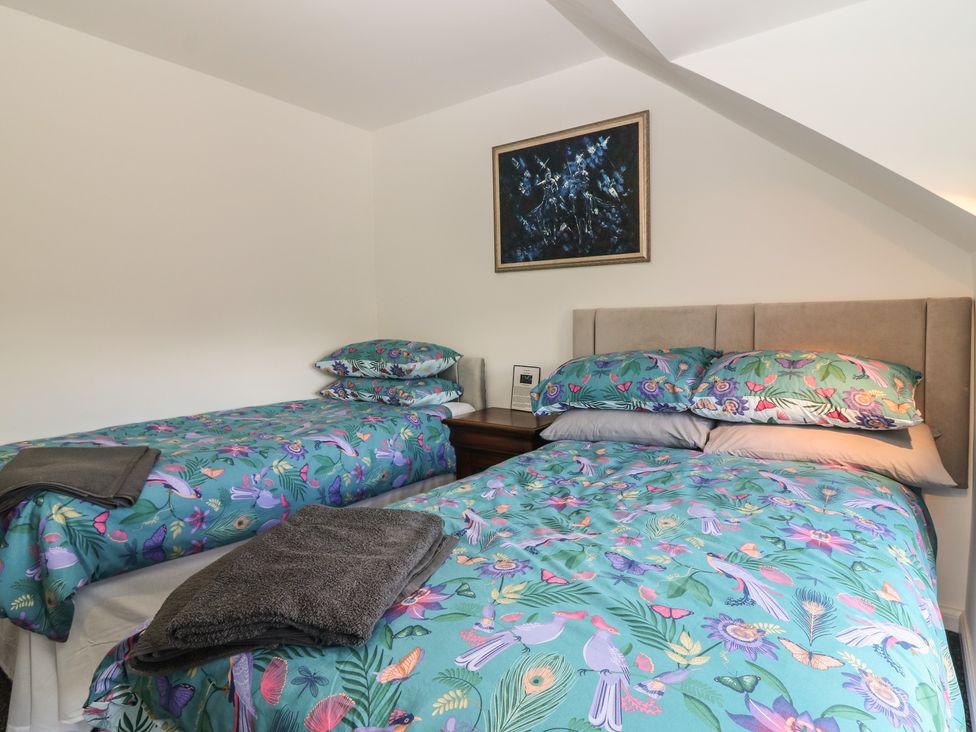 A bedroom with two beds and artwork on the wall at The Old School Peebles