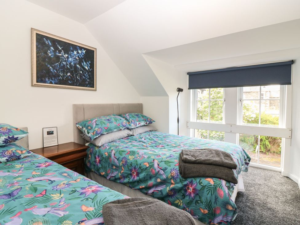 A bedroom with two beds and a painting at The Old School in Peebles
