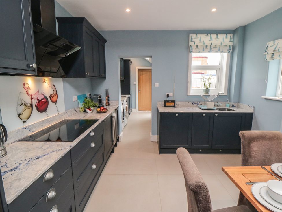A kitchen with cabinets, sink, and dining table at 5 Station Avenue