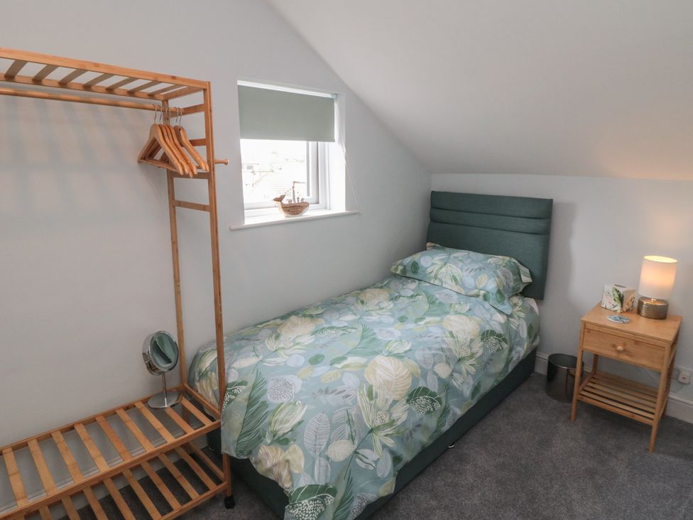 A bedroom with a single bed and a clothes rack at 5 Station Avenue