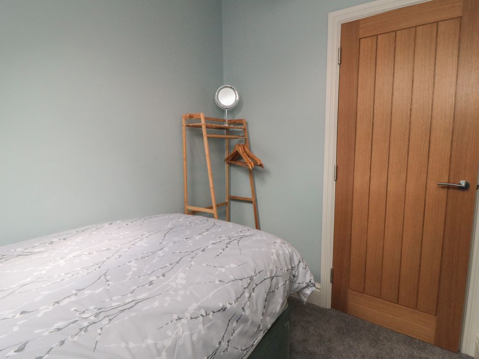 A bedroom with a bed and a clothes rack at 5 Station Avenue