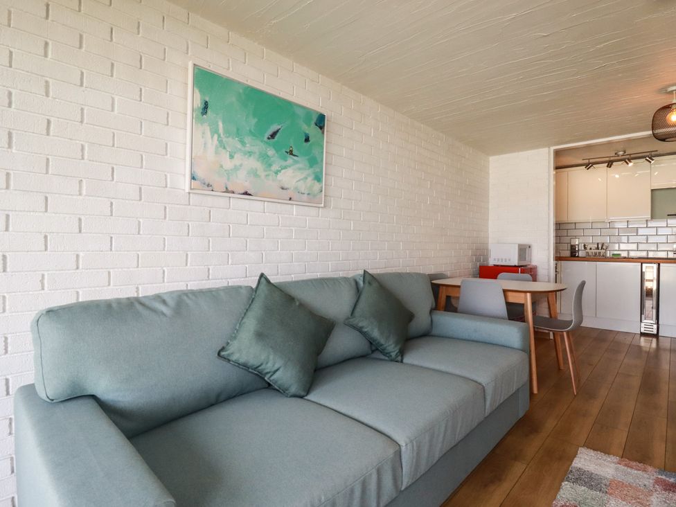 A living room with a sofa and dining area at A5 Bay Apt.
