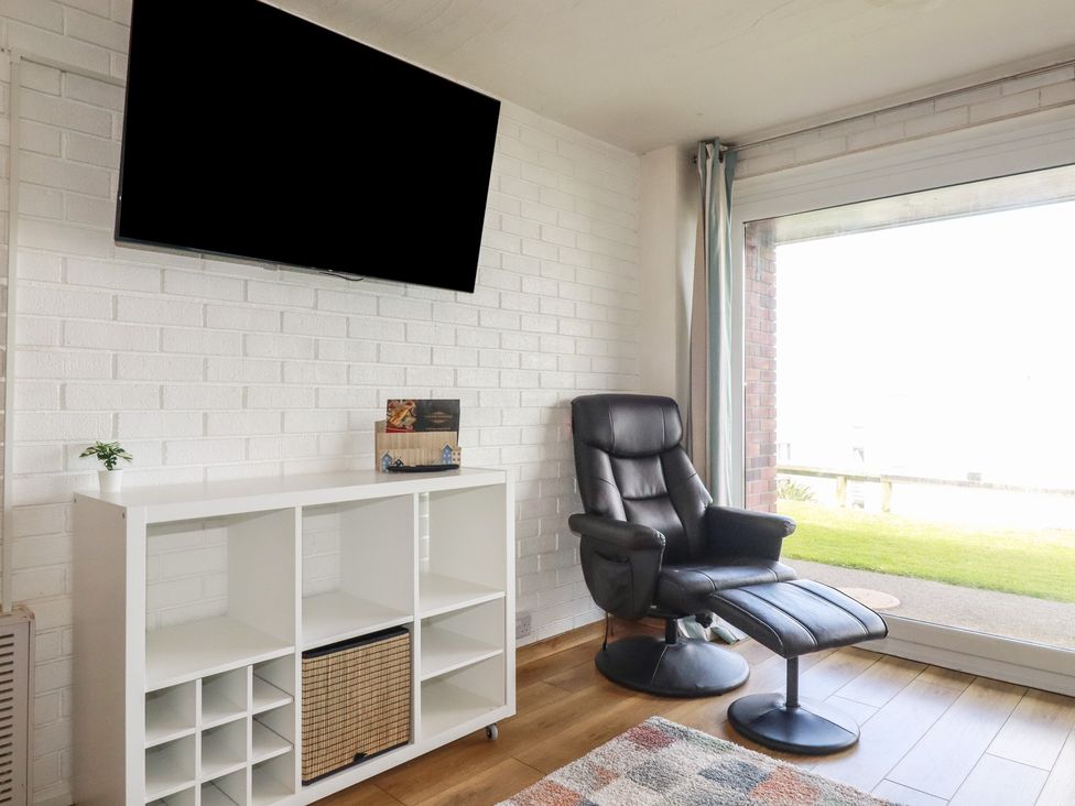 A living room with a television and an armchair at A5 Bay Apt.