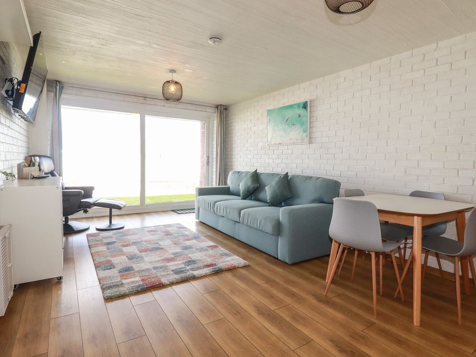A living room with a sofa and dining table at A5 Bay Apt.