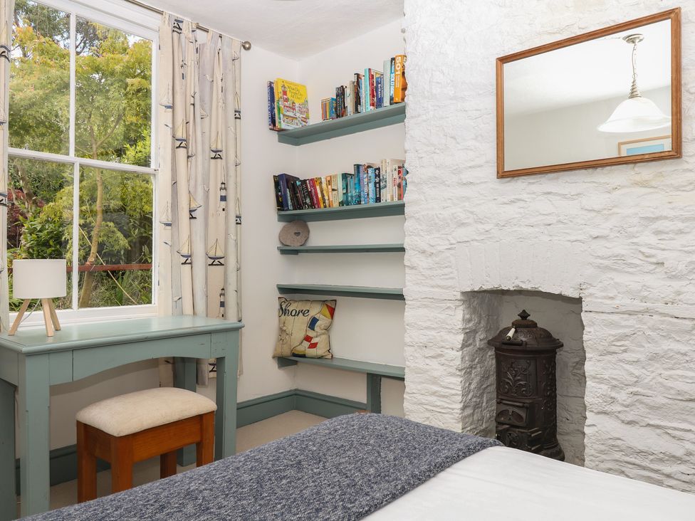 A bedroom with a desk and bookshelf at Tiller Cottage in Dartmouth