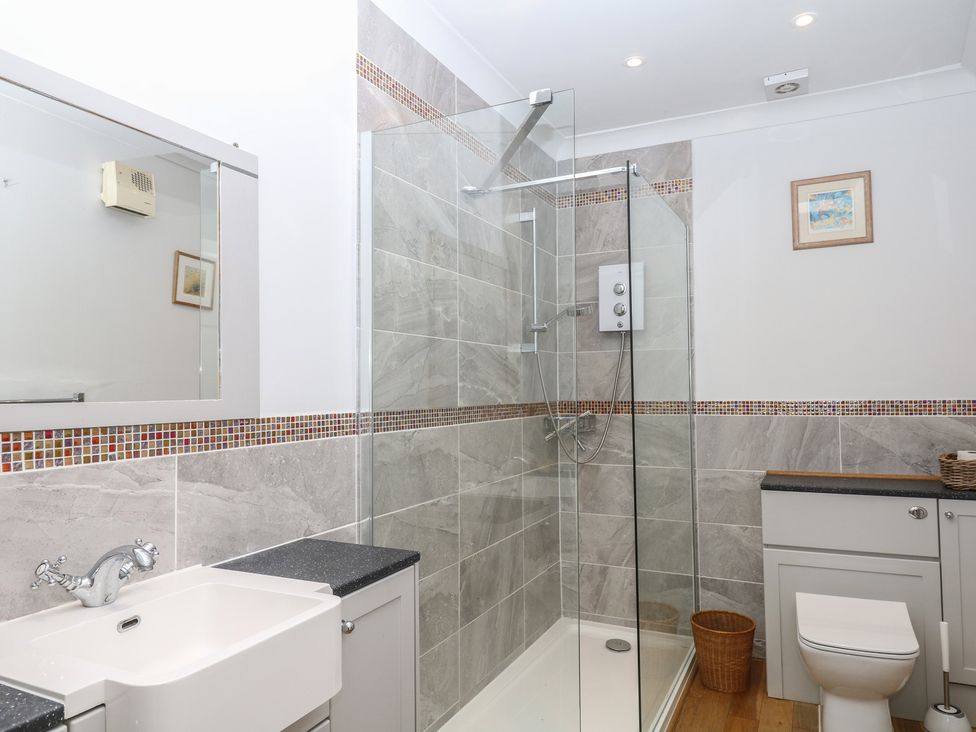 A bathroom featuring a sink, shower, and toilet at Tiller Cottage in Dartmouth