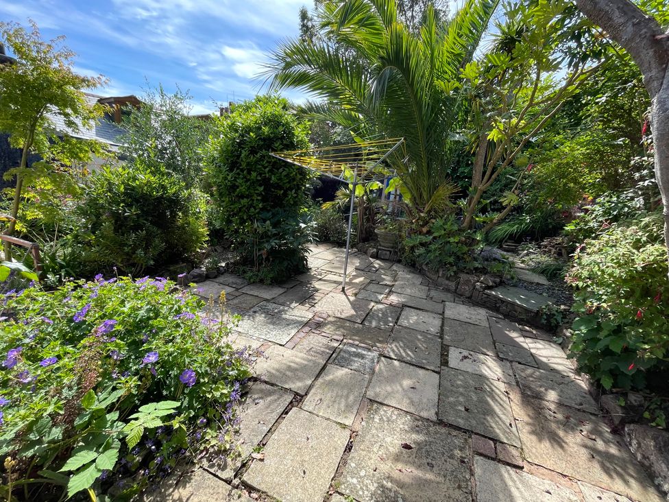 A garden with paving stones and plants at Tiller Cottage in Dartmouth