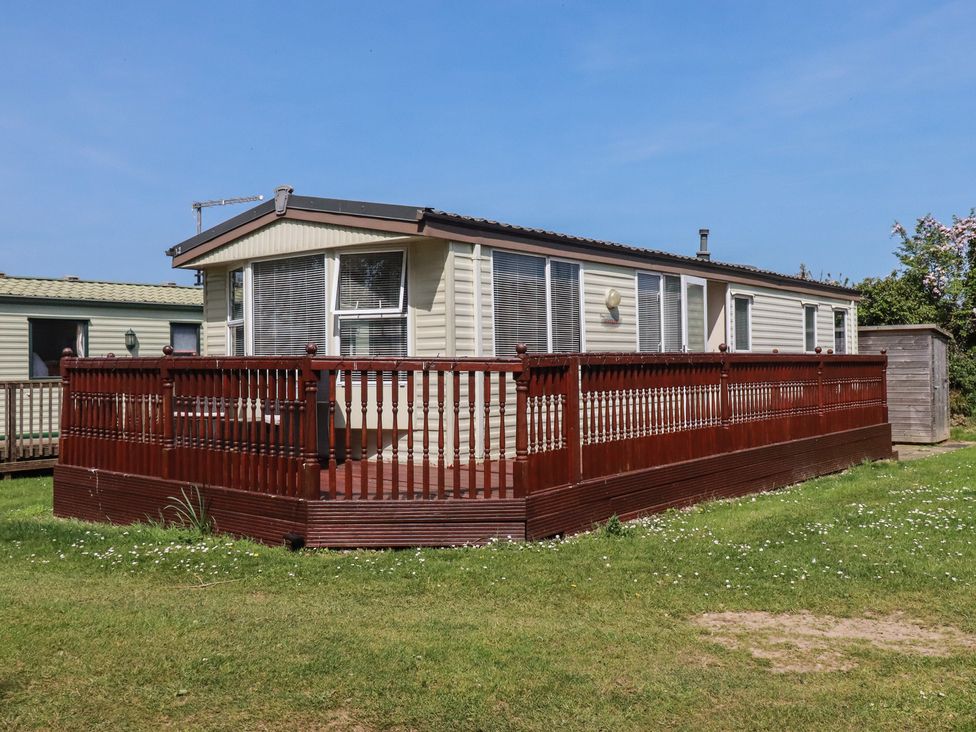 A caravan with decking and steps at Beech Lodge in Wadebridge