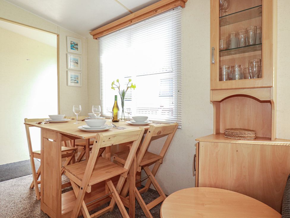 A dining room with a table set for meals at Beech Lodge in Wadebridge