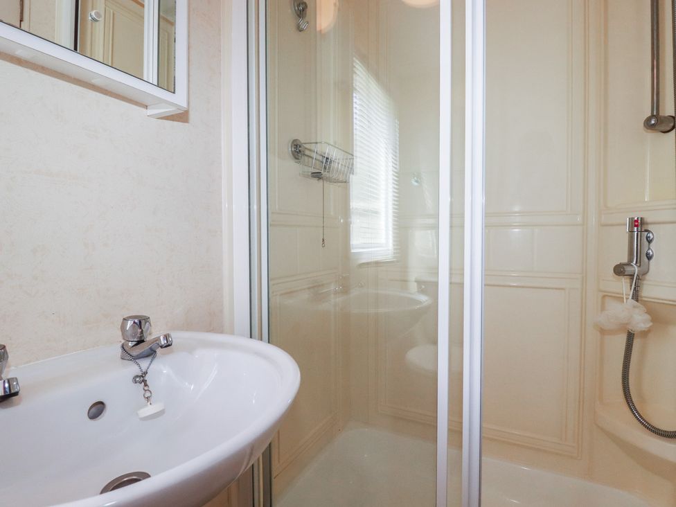 A bathroom with a sink and shower at Beech Lodge in Wadebridge