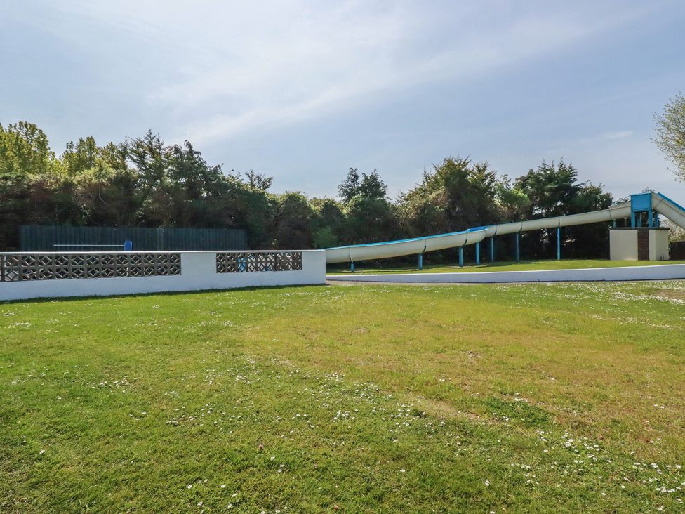 An outdoor space with a water slide and grass at Beech Lodge in Wadebridge