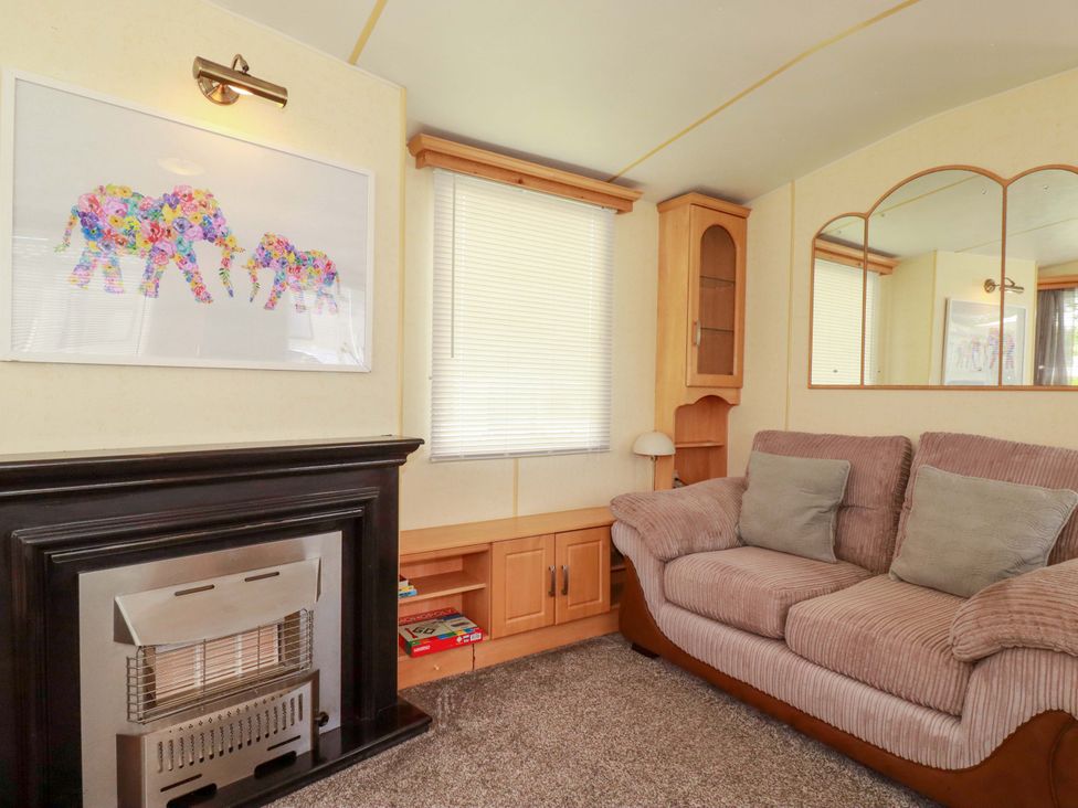 A living room with a sofa and artwork at Beech Lodge in Wadebridge