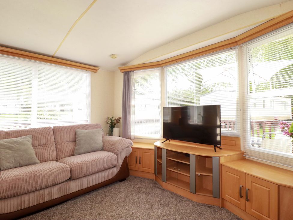 A living room with a sofa and television at Beech Lodge in Wadebridge