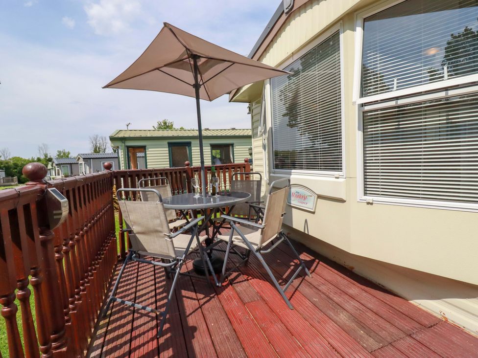 An outdoor seating area with a table and chairs at Beech Lodge in Wadebridge
