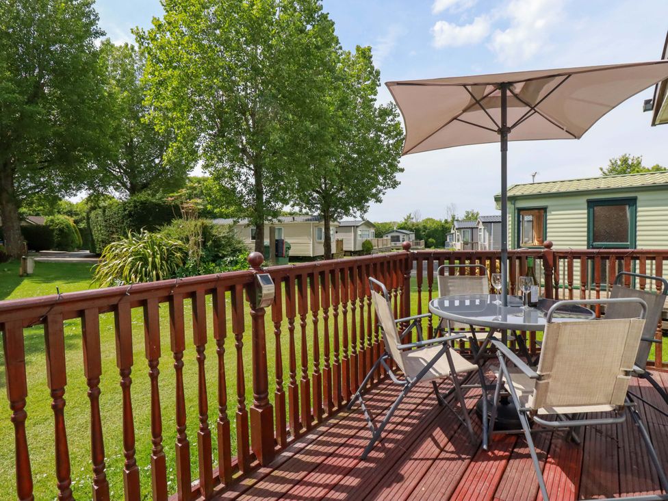 An outdoor area with a table and chairs at Beech Lodge in Wadebridge
