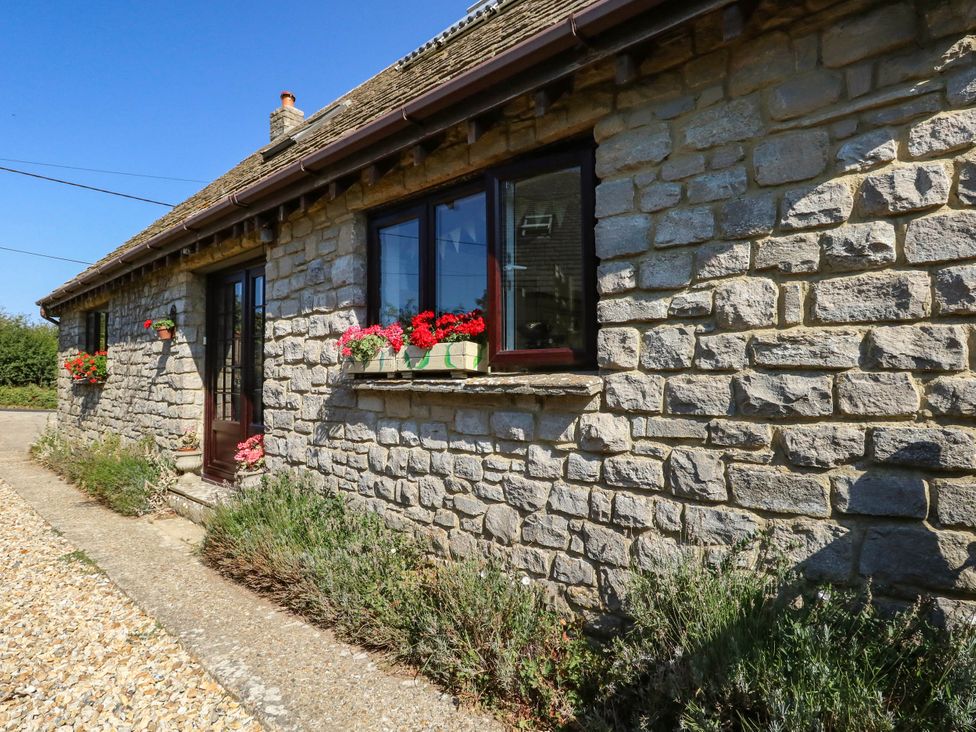 A stone cottage with flowers on the windowsill at Dunvant in Swanage