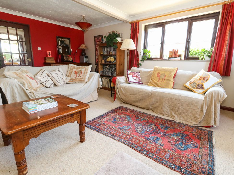 A living room with sofas and a wooden table at Dunvant in Swanage