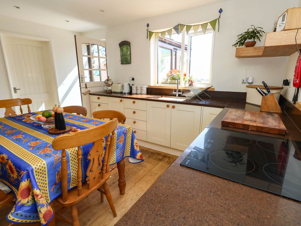 A kitchen with a table and chairs at Dunvant in Swanage
