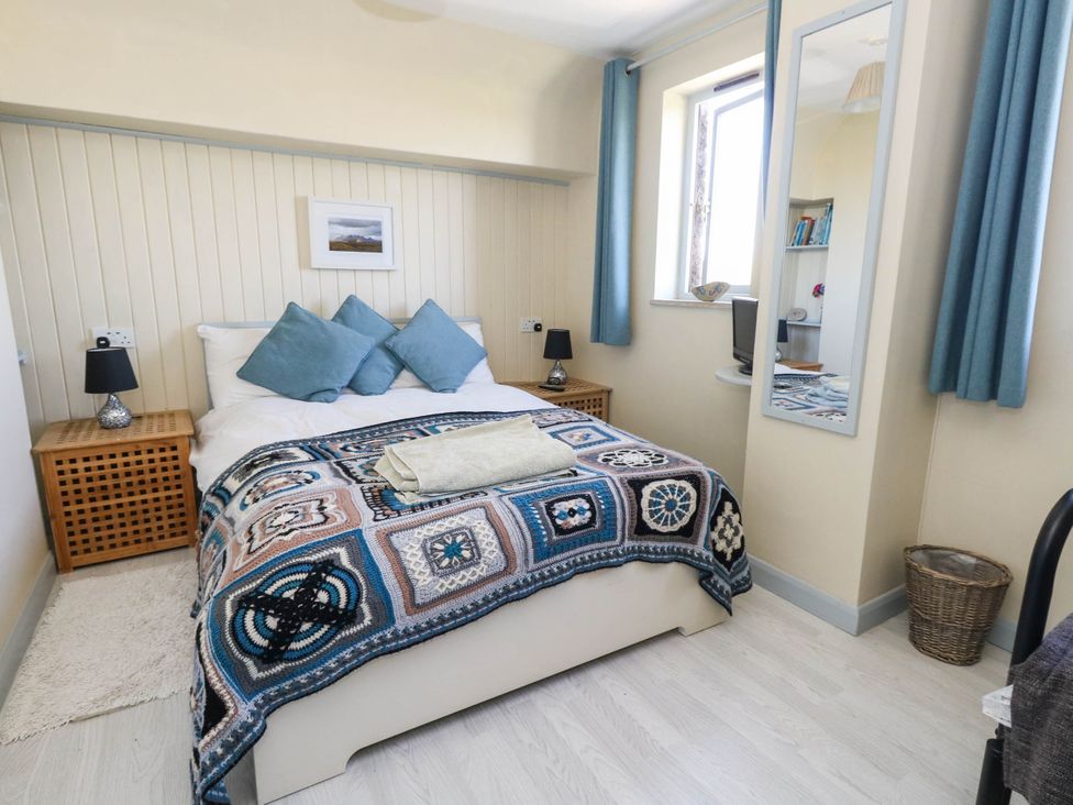 A bedroom with a bed and bedside table at Dunvant in Swanage