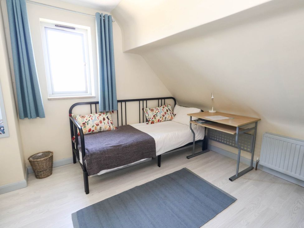 A bedroom with a bed and desk at Dunvant in Swanage