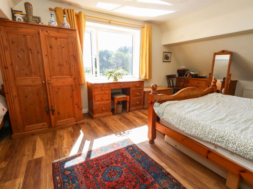 A bedroom with a bed and clothing storage at Dunvant in Swanage