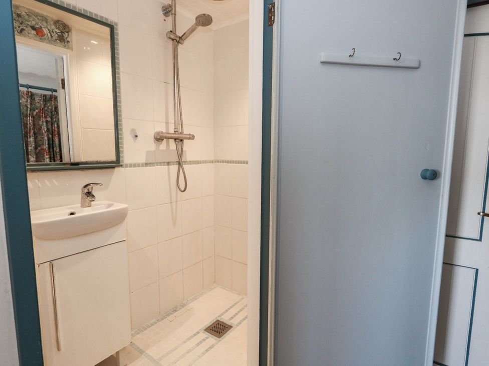A bathroom with a shower and sink at Dunvant in Swanage