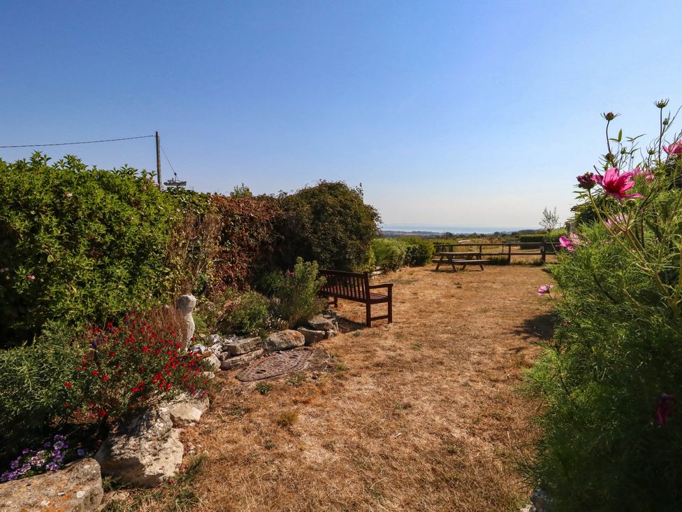 A garden with a bench and table at Dunvant in Swanage