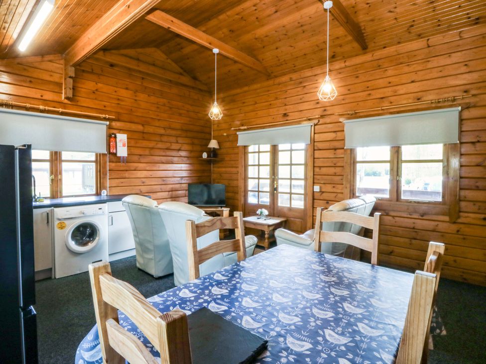 A living room with a dining area and kitchen appliances at Lodge 6 - Sleep 4 - Twin and Double Criccieth