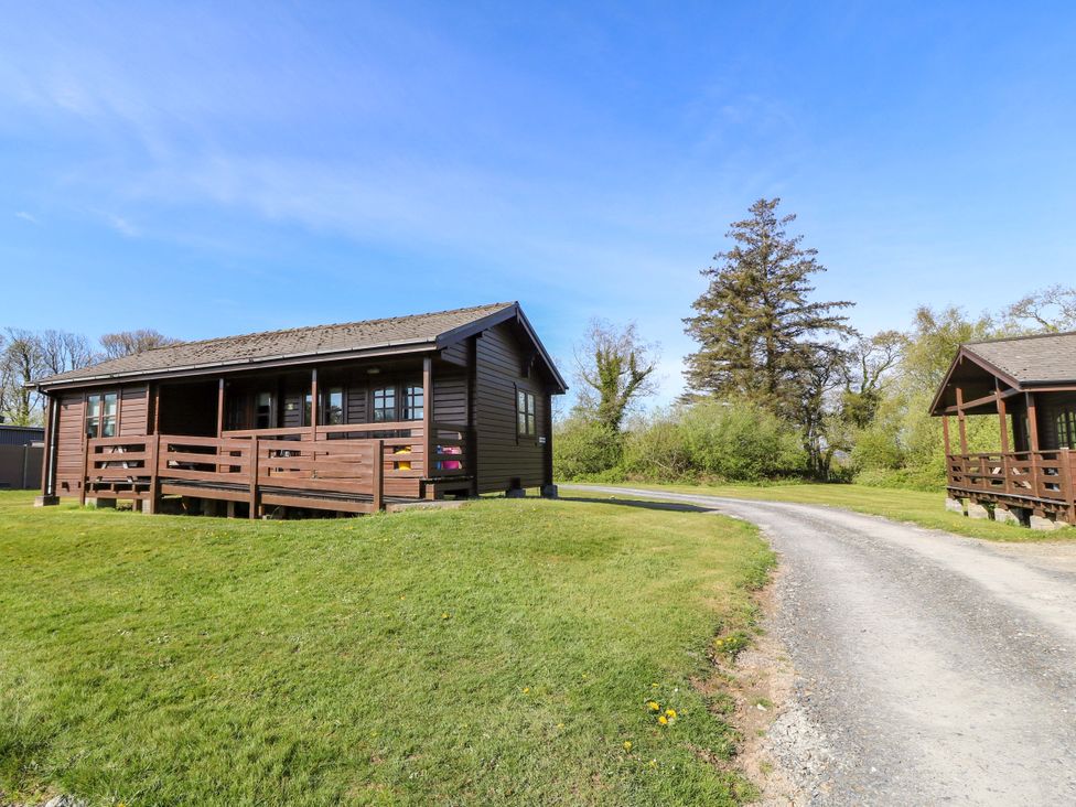 A cabin with a pathway and trees in the background at Lodge 6 - Sleep 4 - Twin and Double in Criccieth