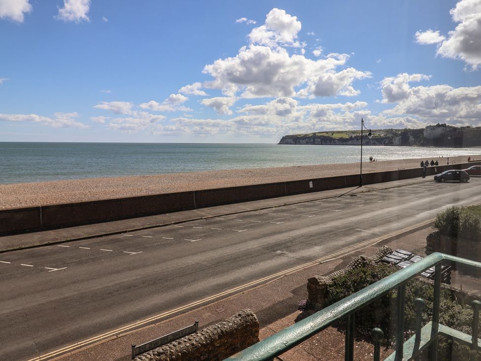 A view of the beach and sea with cliffs in the distance at 2 Lyme Mews Seaton