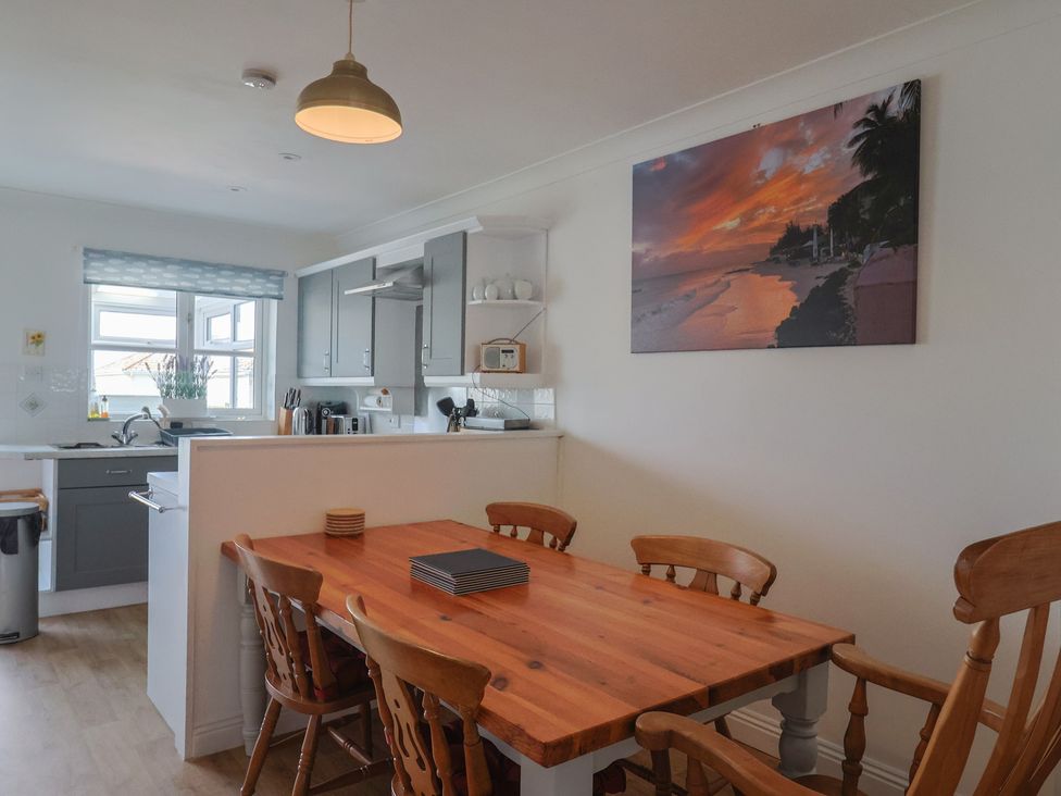 A kitchen with a dining table and chairs at 2 Lyme Mews Seaton