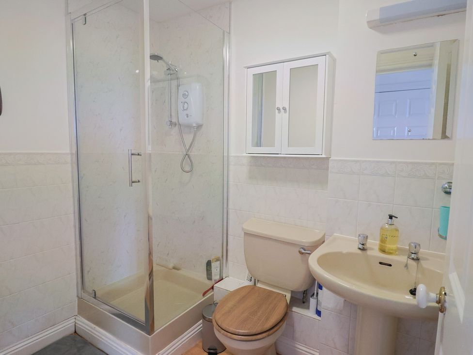 A bathroom with shower, toilet, and sink at 2 Lyme Mews in Seaton