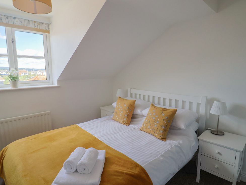 A bedroom with a bed and bedside table at 2 Lyme Mews in Seaton