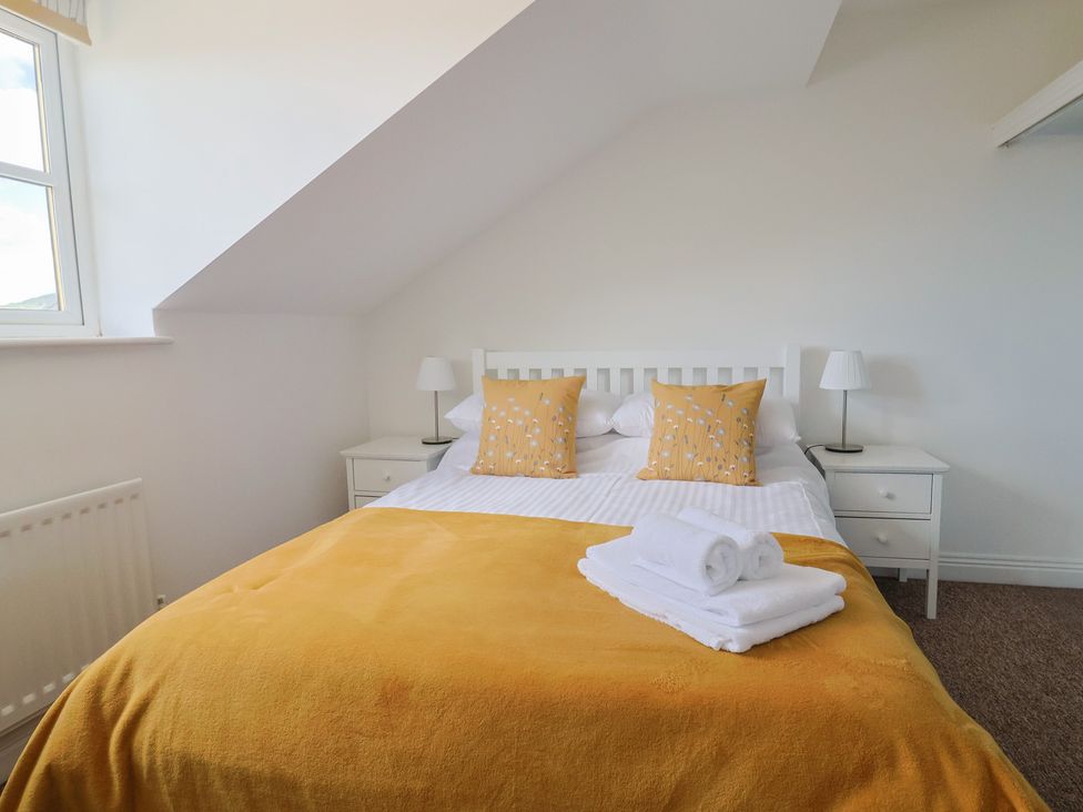 A bedroom with a bed and bedside table at 2 Lyme Mews Seaton