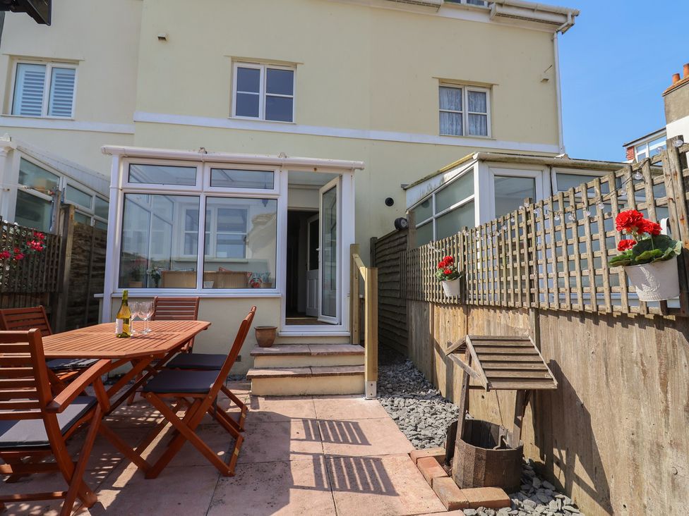 A garden with a patio table and chairs at 2 Lyme Mews in Seaton