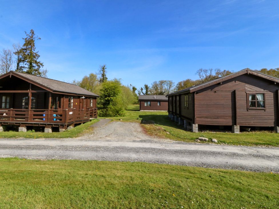Three wooden cabins in an outdoor area at Lodge 8 - Sleep 4 - Double and Twin, Criccieth