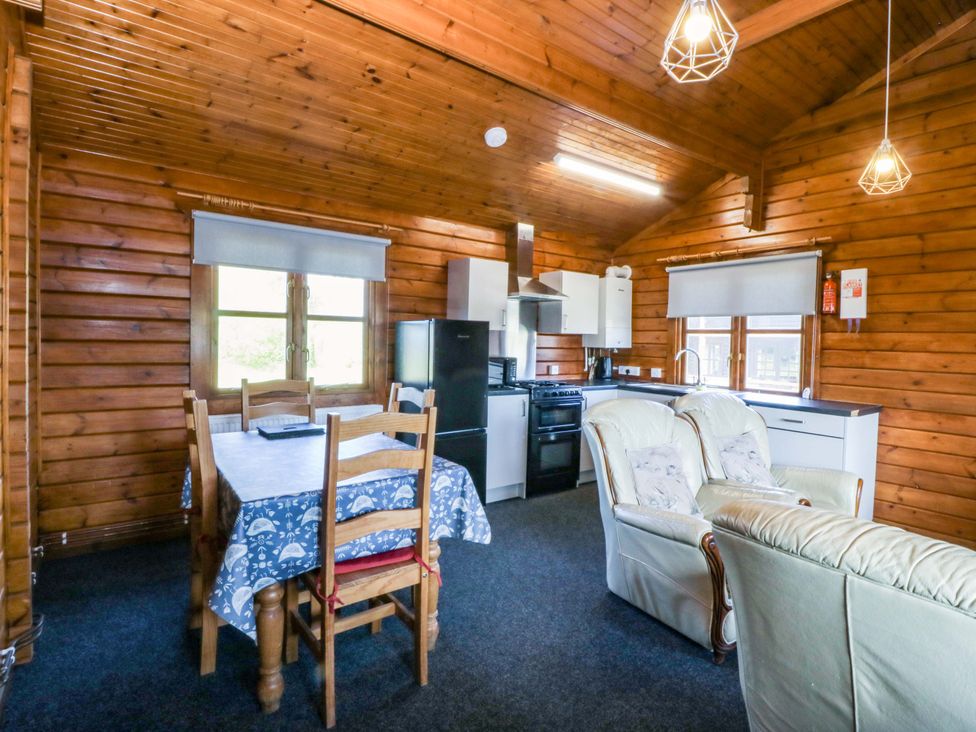 A kitchen area with a table, chairs, and a sofa at Lodge 9 - Sleep 4 - Double and Twin, Criccieth