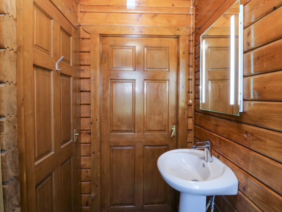 A bathroom with a sink and wooden paneling at Lodge 9 - Sleep 4 - Double and Twin in Criccieth